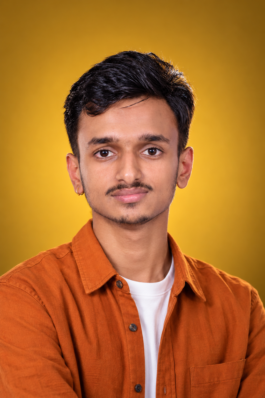 Portrait of Aaditya against a warm golden background
